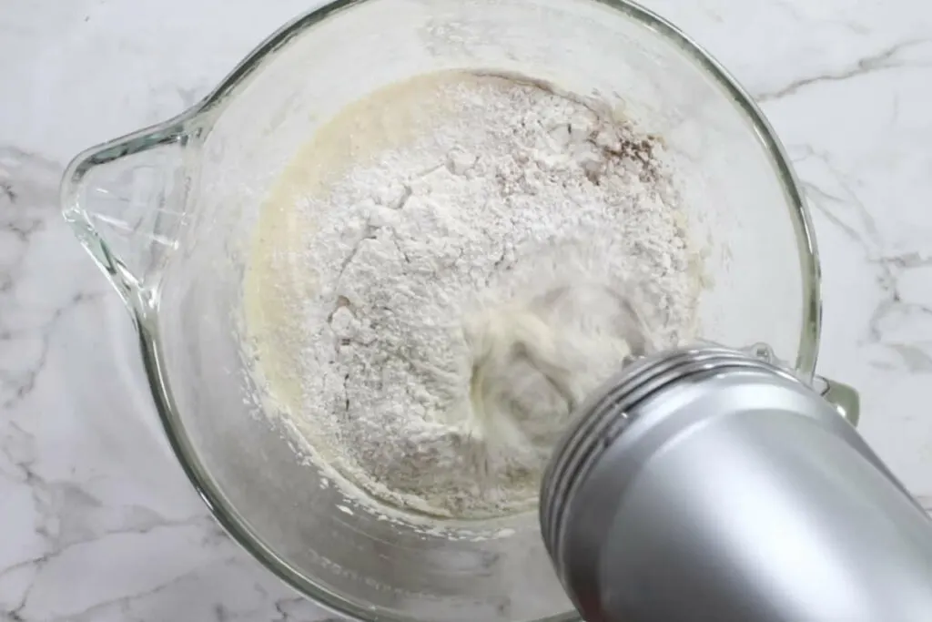 Mixing flour and spices into cake batter.