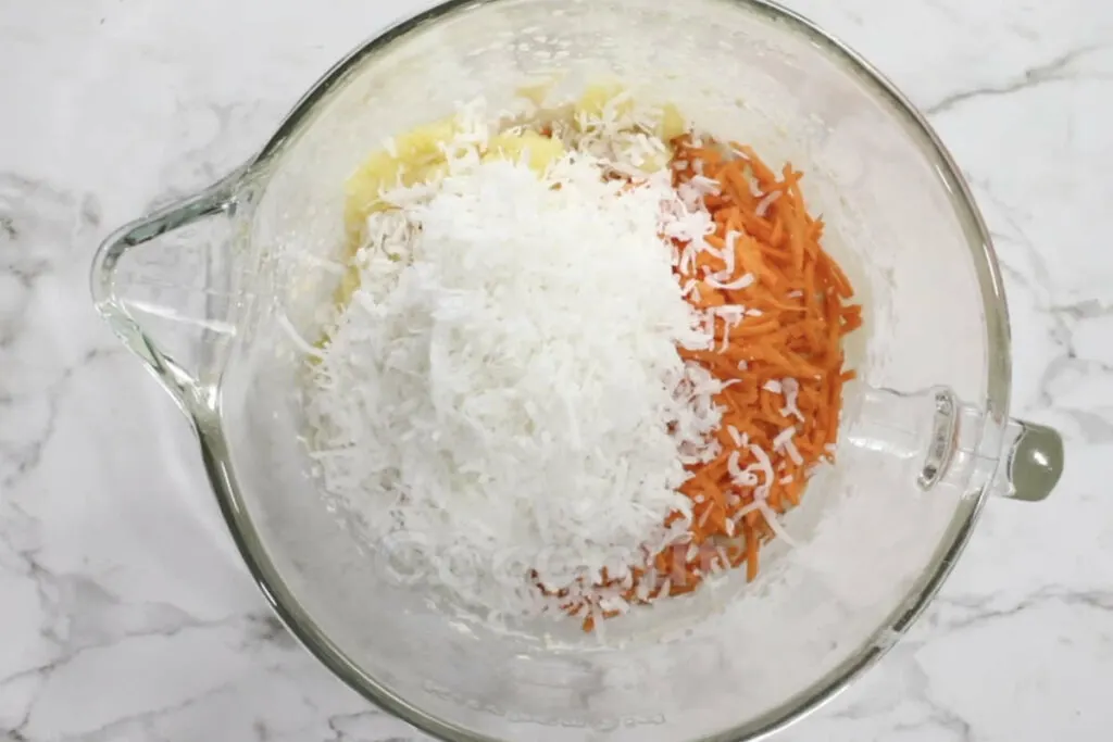 Stirring pineapple, coconut and carrots into cake batter.