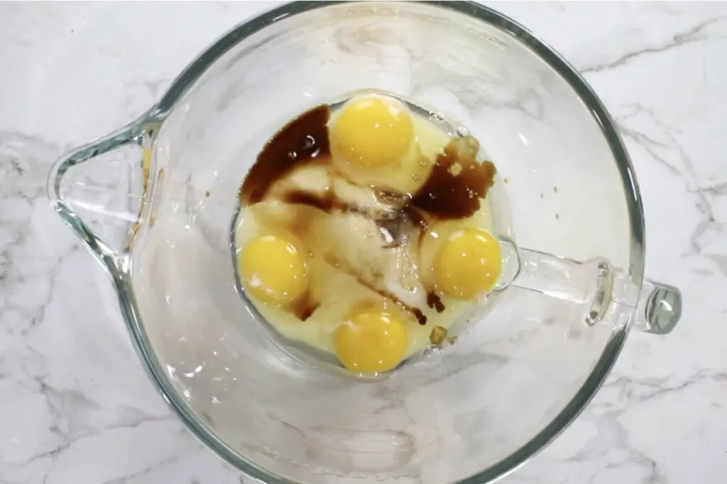 Whipping eggs and sugar in a mixing bowl.