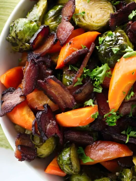 Carrots and brussels sprouts in a serving bowl with bacon.