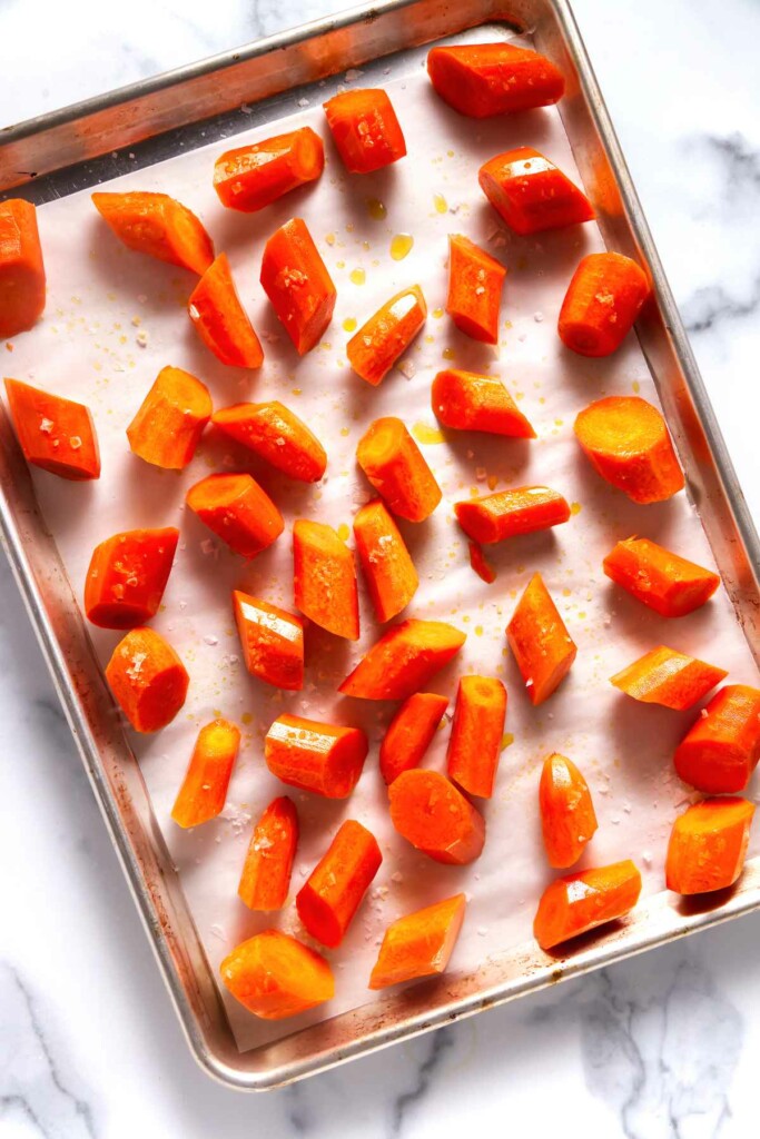 Sliced carrots on a sheet pan.