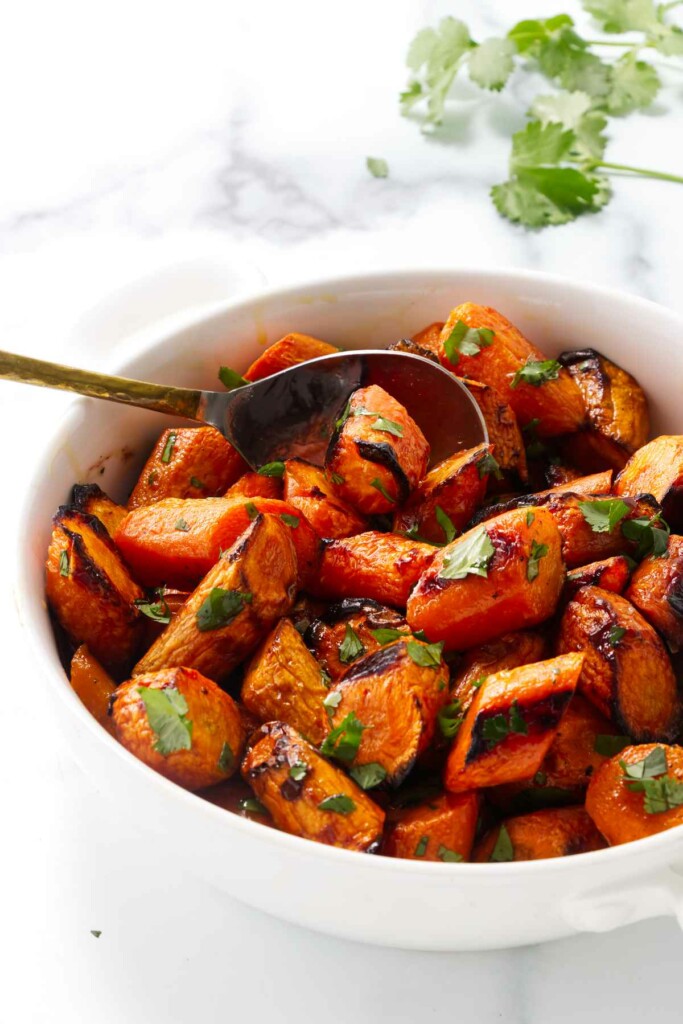 Roasted cilantro lime carrots in a bowl with a spoon.