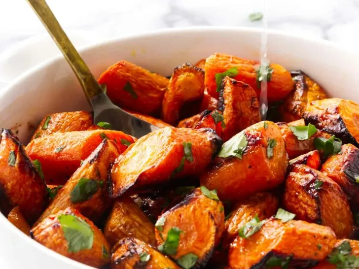 Squeezing lime in a bowl with carrots and cilantro.