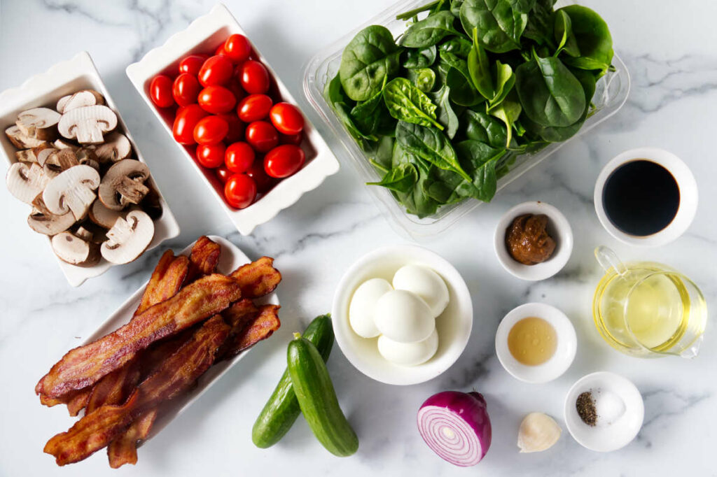 Ingredients used to make a spinach salad with bacon and balsamic vinaigrette.