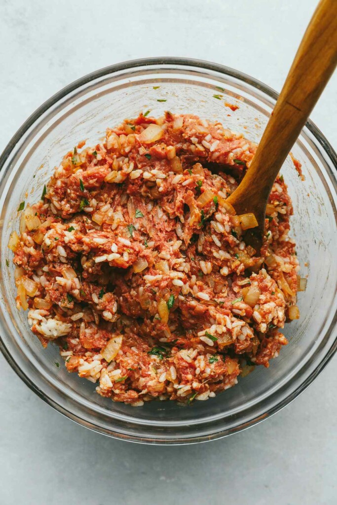 Mixing cabbage roll filling in a bowl.