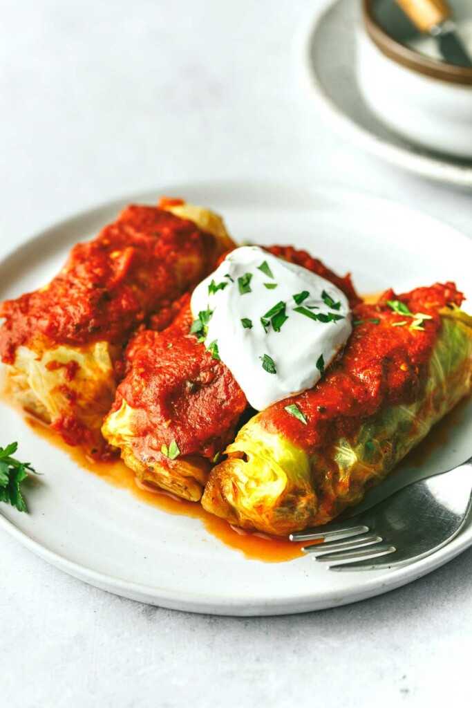 baked stuffed cabbage wraps topped with sour cream and chives.