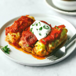 Sausage and beef stuffed cabbage rolls on a plate with a fork.