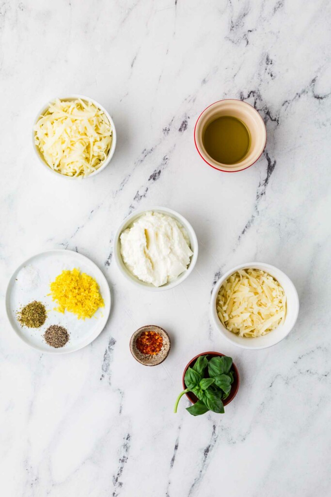 Ingredients used to make a warm baked ricotta dip appetizer.