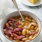 A spoon in a bowl of homemade garlic butter beans.