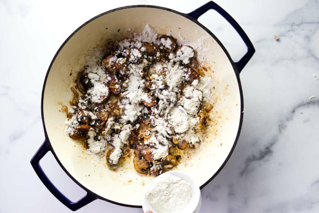 Adding flour to mushroom sauce for chicken.