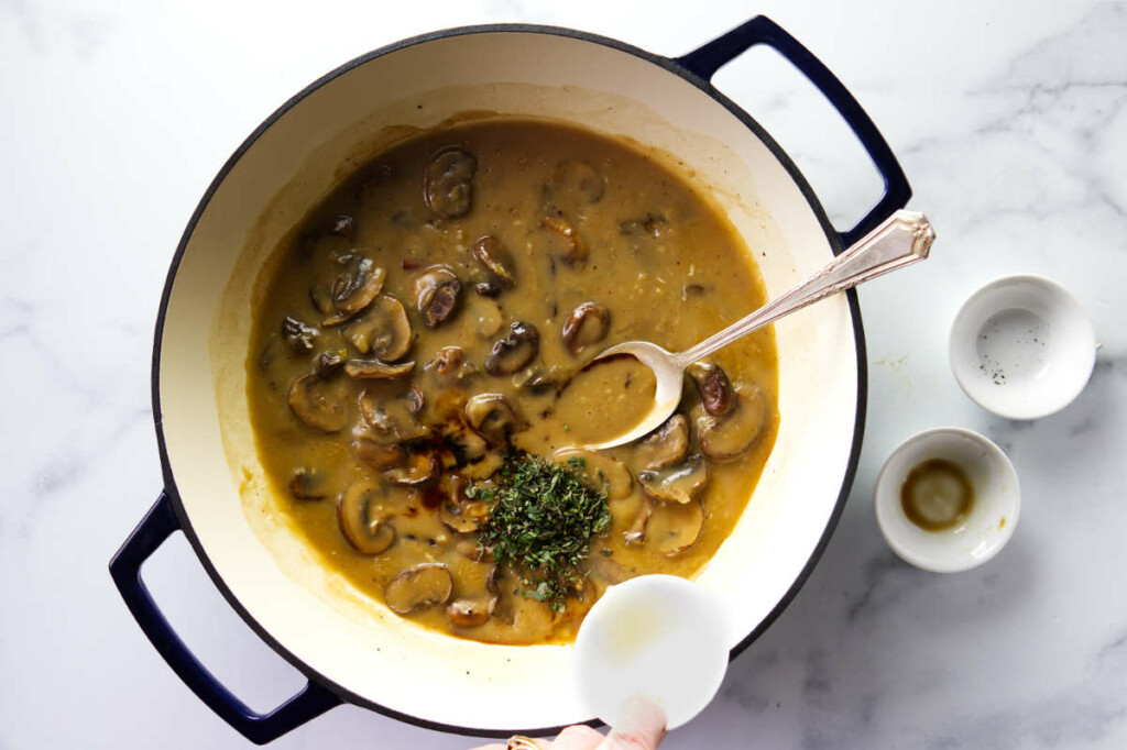 Adding herbs to the mushroom sauce for chicken breast.