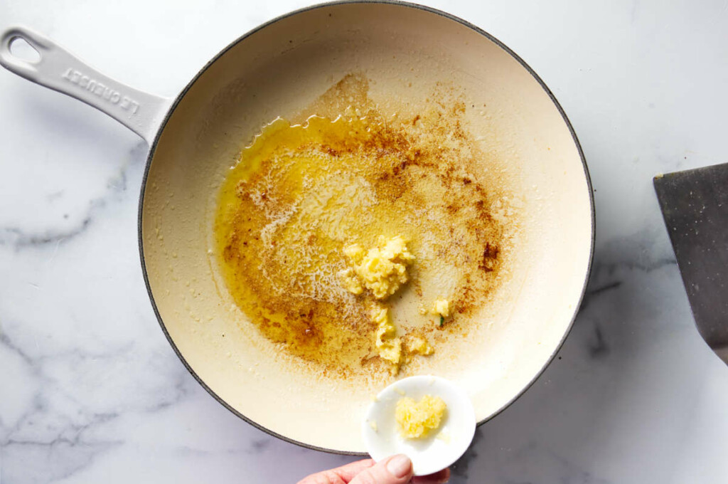 Adding garlic to a hot skillet.