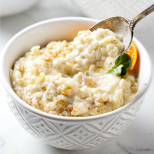 A spoon in a bowl of creamy rice pudding made with short grain rice.