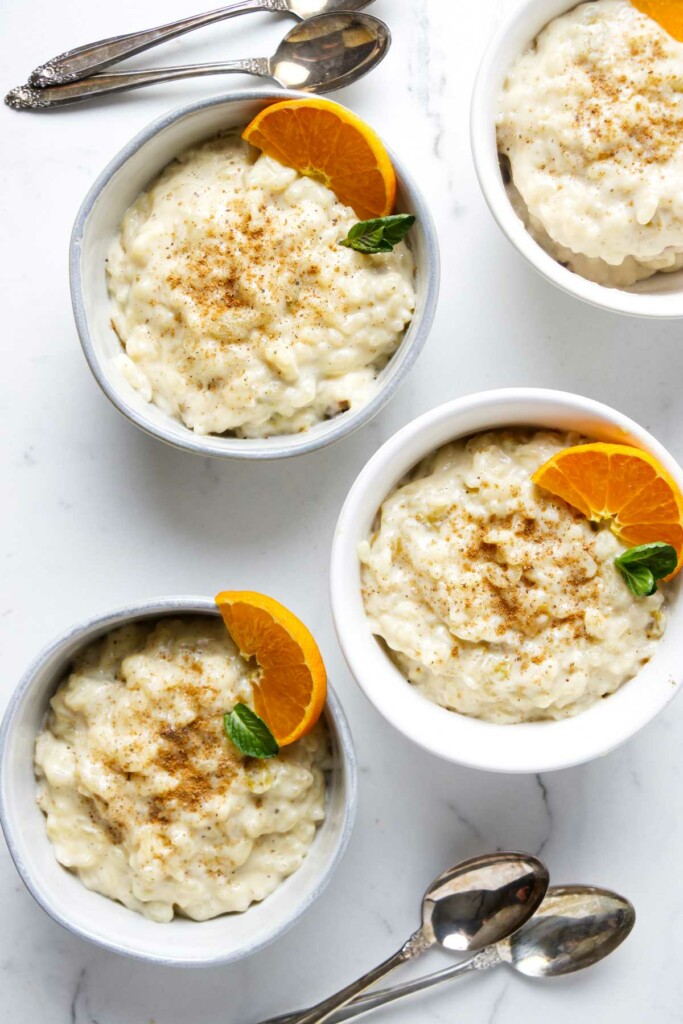 Four bowls of creamy rice pudding made with milk.