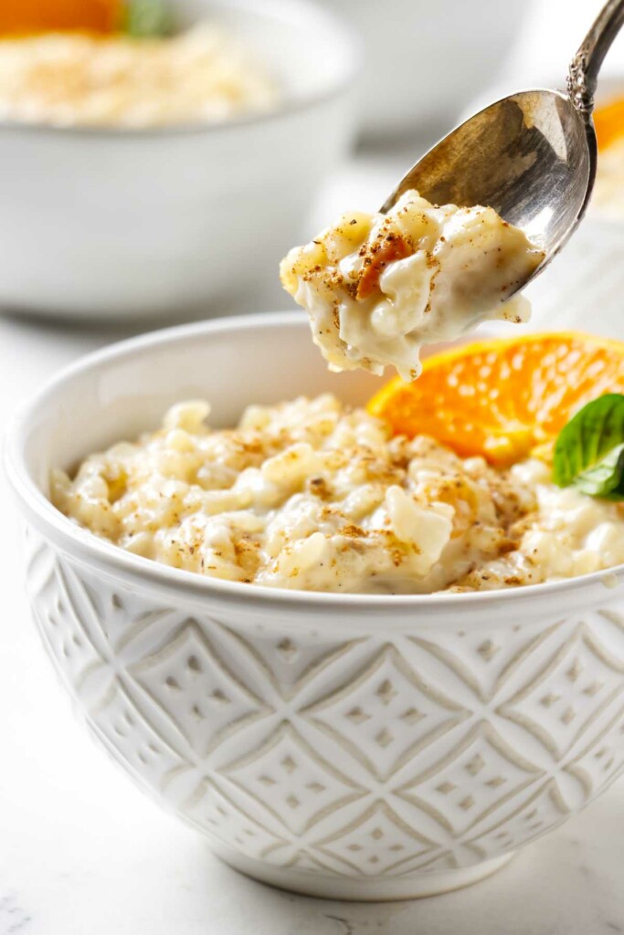 A spoon in a bowl of a simple rice pudding recipe.