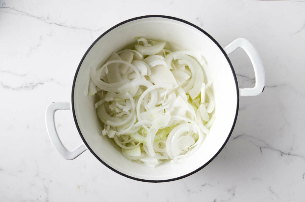 Sliced onions in a dutch oven prior to cooking them.