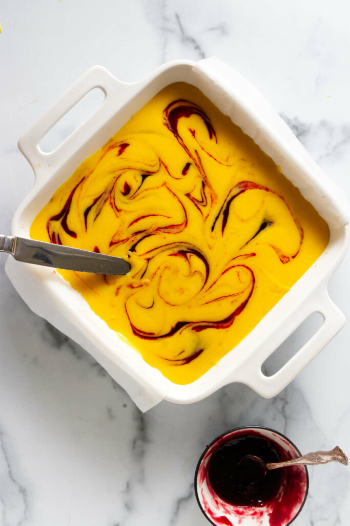 Swirled raspberry mango bar batter in a dish.