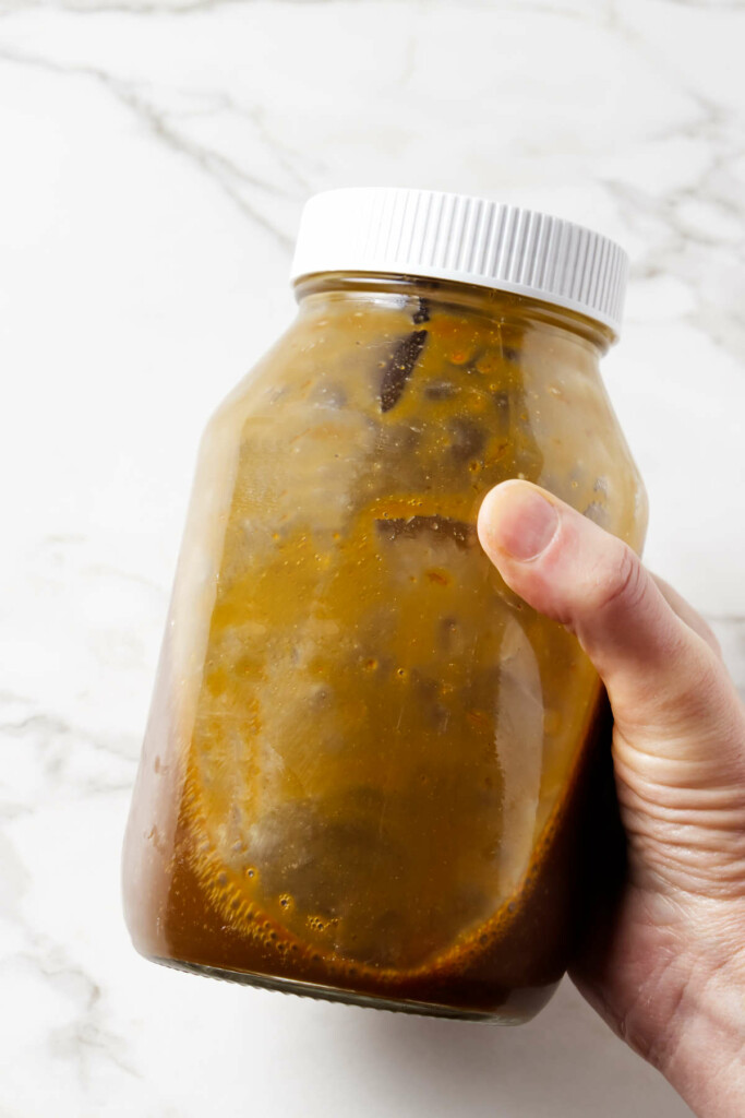 Shaking a recipe for stir fry sauce in a quart jar.