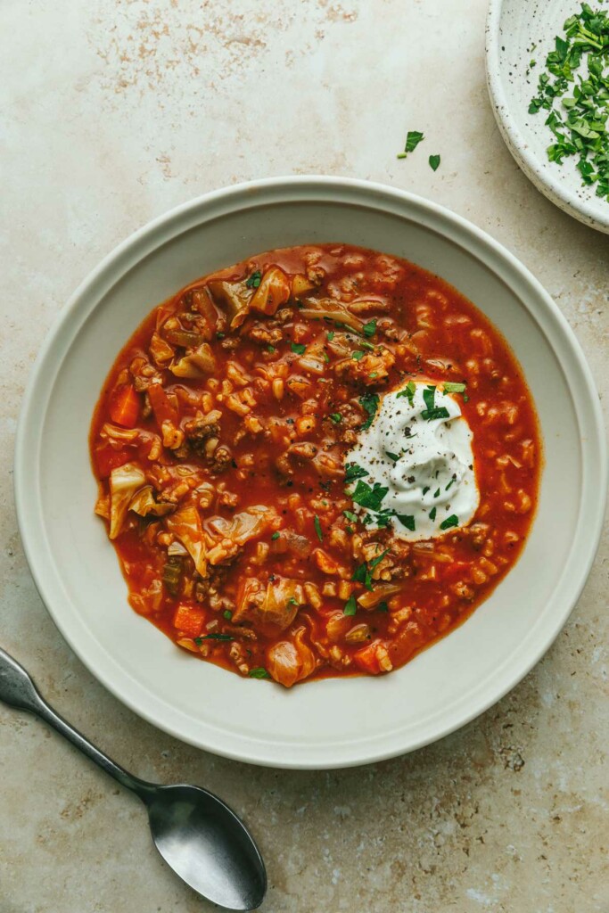 A bowl of galumpkis soup with a dollop of sour cream.