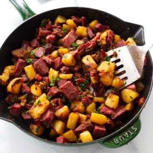 Corned beef hash in a skillet with a spatula.