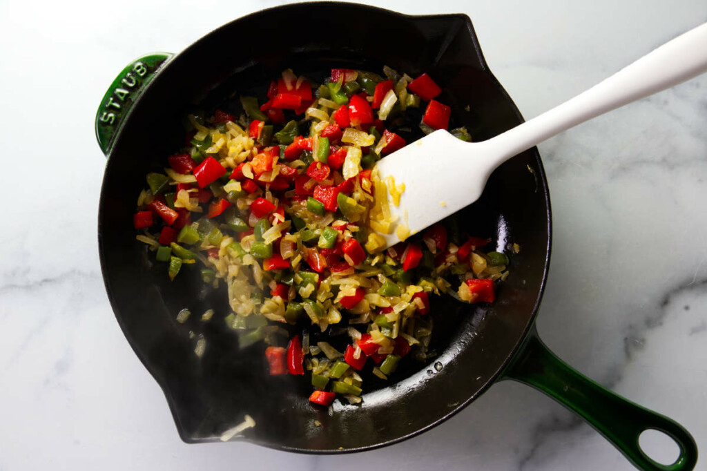 Sautéing peppers and onions in a skillet.