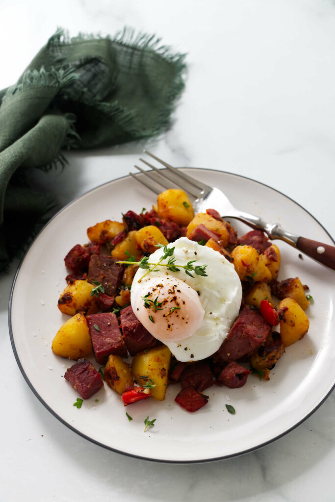 Corned beef and hash on a plate with a poached egg.