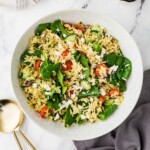 An orzo lemon feta salad in a large white bowl.