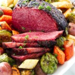 A platter of corned beef with potatoes and brussels.