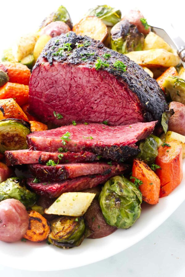 A platter of corned beef with potatoes and brussels.