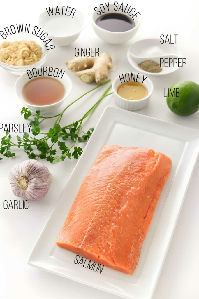 Raw salmon fillet with labeled seasoning ingredients arranged on a white surface.