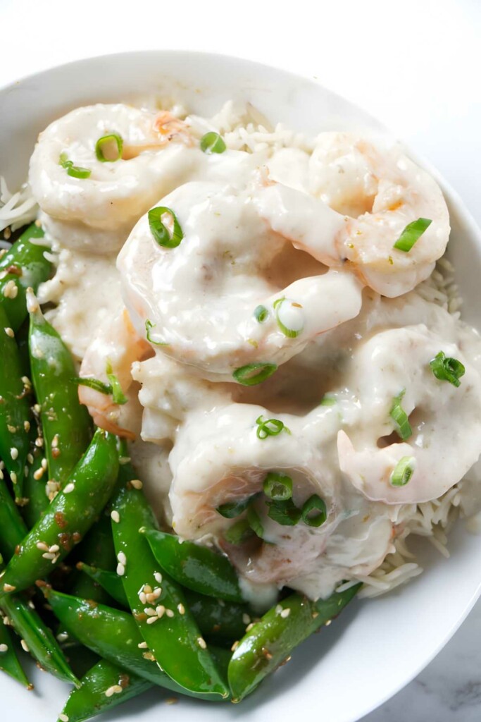 Creamy shrimp over rice with green onions, sugar snap peas, sesame seeds.