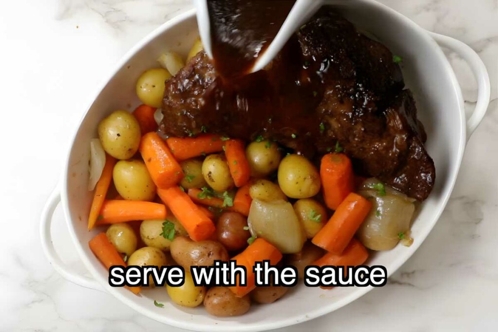 Tri tip with vegetables and sauce being poured over in white dish.