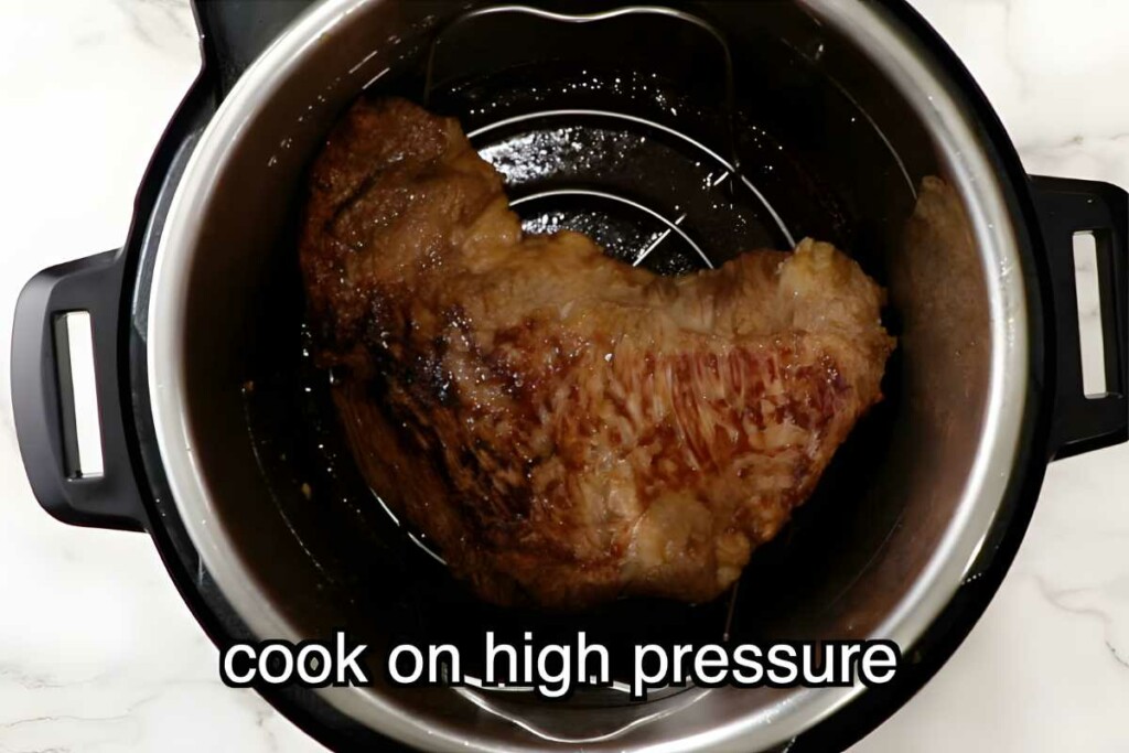 Browned and seared tri tip on rack in Instant Pot; text.