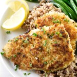 Two fillets of crispy fried rockfish on a plate with rice.