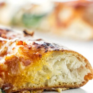 Close-up of pizza slice showing airy crust and melted cheese.