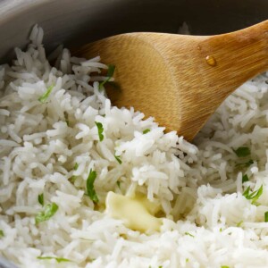 A wooden spoon in a pot with rice.