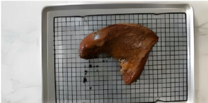 Placing the tri tip on a baking sheet before putting it in the oven.