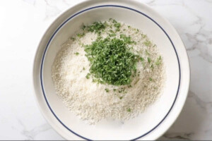 Combining panko, parsley, and Parmesan cheese in a dish.