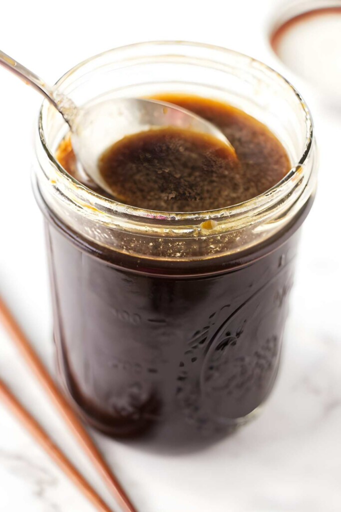 A spoon in a jar of fried rice sauce.