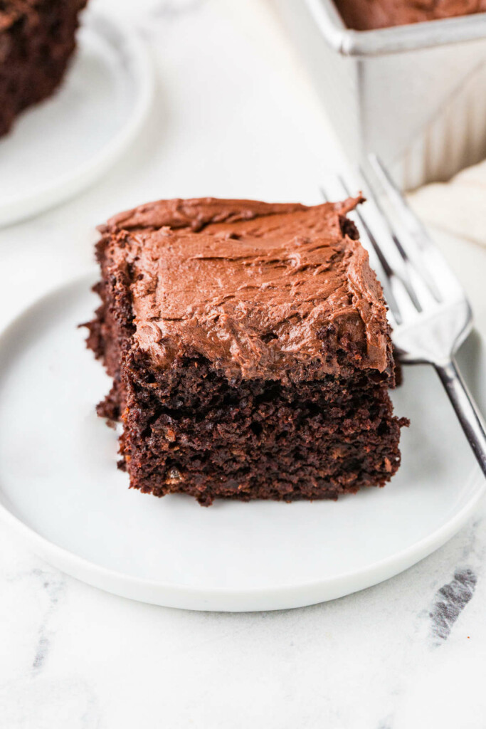 A slice of chocolate sourdough cake topped with chocolate buttercream.