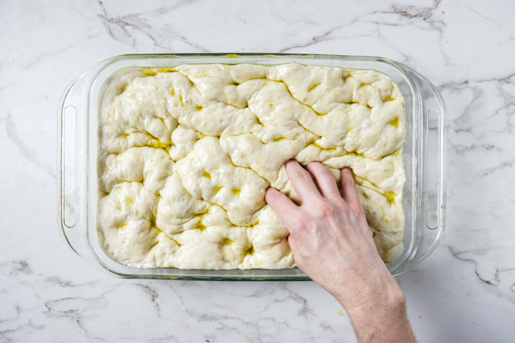 Using fingertips to push down into the dough.