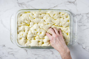 Using fingertips to push down into the dough.