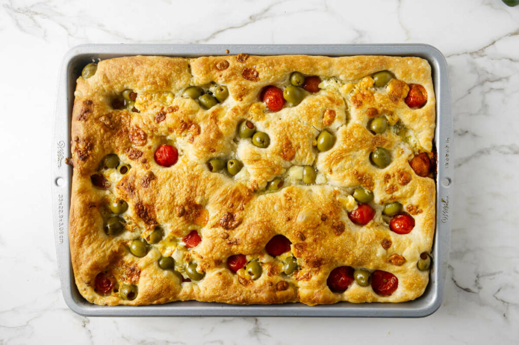 Sourdough focaccia with olives and tomatoes on top.