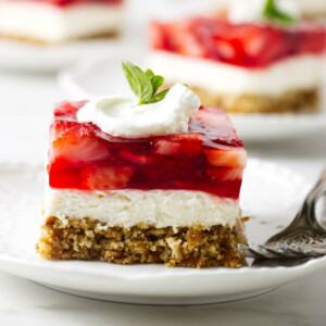 A slice of strawberry and pretzel dessert on a plate.