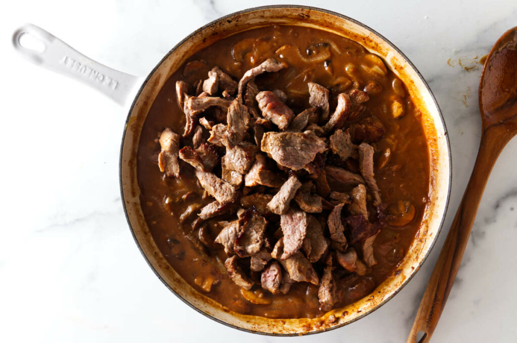 Adding the beef strips back to the stroganoff sauce.