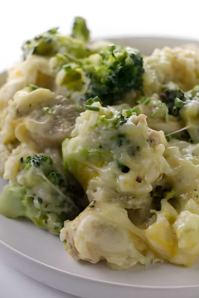 Cheesy broccoli and chicken casserole close-up on a white plate.