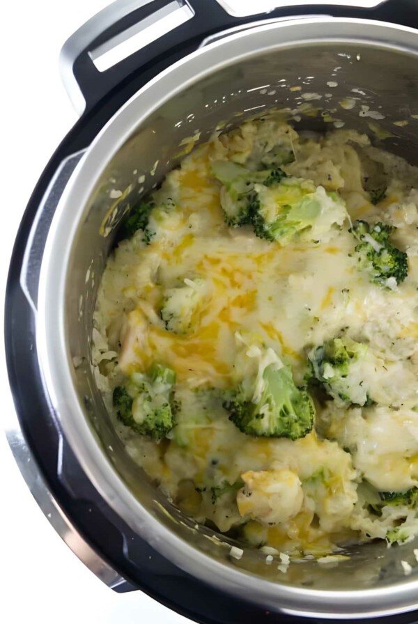 Close-up of Instant Pot with cheesy broccoli and rice casserole inside.