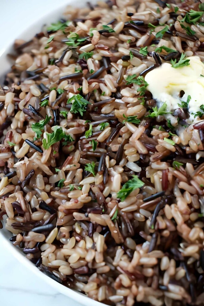 Close-up of wild rice blend with parsley and melting butter on top.
