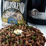 Bowl of wild blend rice with butter, herbs, Instant Pot, and rice bag.