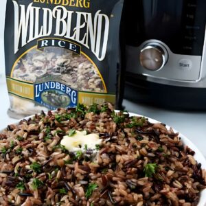 Bowl of wild blend rice with butter, herbs, Instant Pot, and rice bag.